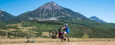 optibike-r17-wheelie-wide Optibike R17 E-Bike doing a wheelie in front of a large mountain