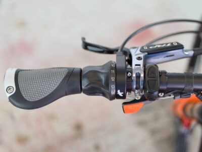 r22-orange-rohloff-brake-dropper-lever Left side of handlebar with Rohloff gear shifter, display controls, and seat post dropper lever