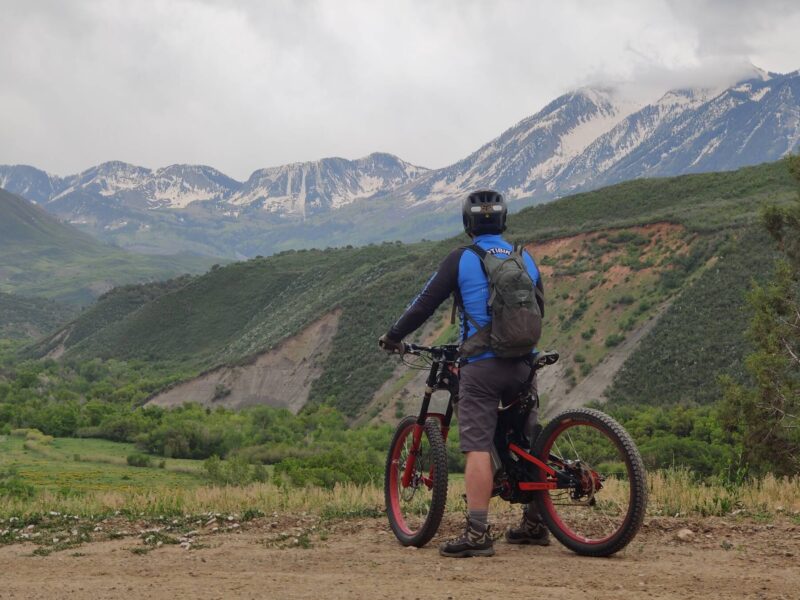 minn-creek-snowy-peaks A person on an Optibike looking out at snowy mountain peaks